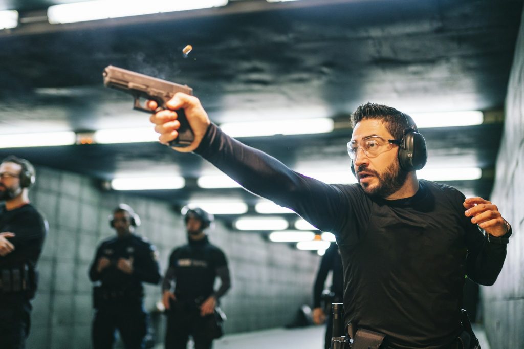 Police training in shooting gallery with short weapon.